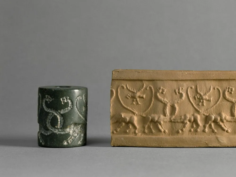 Small cylinder with images on it next to long piece of clay with corresponding images